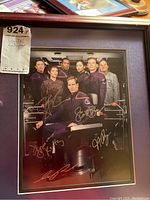Full view of framed photograph print of Star Trek Enterprise cast with signatures and a sticker showing lot number and description.
