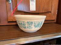 Full side view of the vintage Pyrex bowl showing the detailed blue Homestead pattern.