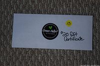 Photo of the $20 gift certificate envelope with the Green Heart Kitchen logo and handwritten value.