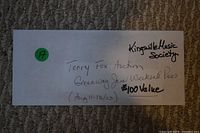 Photo showing the Greenway Jam Weekend Pass. Rectangular paper slip with handwritten event details and $100 value.