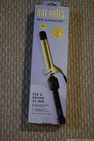 Boxed Hot Tools Pro Signature curling iron showing gold 25mm barrel and black handle with clamp and temperature dial.