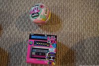 Photo of LOL Surprise Remix Pets Cube and LOL Surprise Family Ball on carpeted floor.
