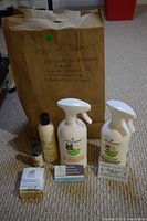 Photo shows Altitude branded cleaning and toiletries from Main Street Pharmacy, including linen essential oil spray, ocean bubble soap spray, body lotion, soap bar, a small essential oil bottle, and two informational cards, all placed in front of a brown paper bag with handwritten notes.