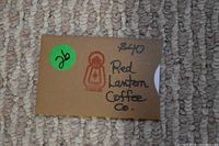 Brown envelope labeled with $40 Red Lantern Coffee Co. and a small red lantern logo on beige carpet.