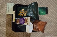 Photo shows items including Starbucks gift certificate, butter-flavored popcorn, Starbucks Siren's blend coffee, green Starbucks travel mug, disposable Starbucks coffee cup, and chocolate covered almonds.