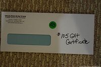 Envelope containing the gift certificate from Warkentin Plumbing, Heating & Air Conditioning with handwritten note indicating $105 value.