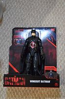 Photo showing Wingsuit Batman action figure in original packaging on carpeted floor.