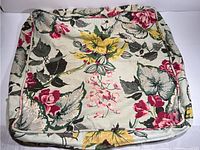 Overall view of a floral barkcloth cushion cover showing fabric pattern and condition