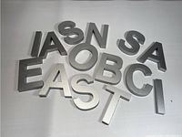 Metallic and acrylic letters arranged on white background to display shapes and sizes.