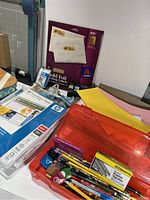 View of assorted office supplies including paper reams, envelopes, stationery items, and labeling supplies