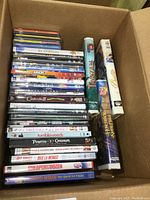 Box showing top view with stacked DVDs and two visible VHS tapes