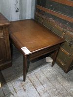 Side view of the vintage wooden end table showing rectangular top and tapered legs.