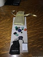Top view showing the collection of polished stones including the large amethyst crystal, various tumbled stones, and two fabric pouches on a wooden surface