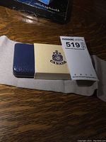 Original blue leatherette case with gold embossed Canadian emblem, and cardboard sleeve with Canada coat of arms.