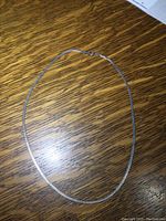 Full view of the necklace laid out on a wooden surface showing its length and clasp.