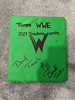 Front cover of the green binder with handwritten titles and WWE logo.