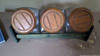 Top view showing three glass canisters with round wooden lids on the green pine tray.