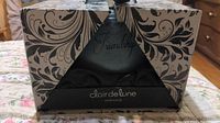Photo of the Clair de Lune Ambiance candle gift set in its original decorative box wrapped in black fabric.