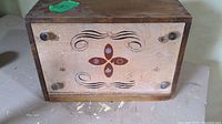 Top view of wooden bread box showing decorative front panel with floral inlay and dovetail joints