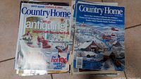 Stack of Country Home magazines showing front covers with topics like antiques and holiday homes.