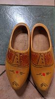 Top-down image of the pair of handpainted Dutch wooden shoes, showing carved and painted patterns on the surface.