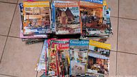 Multiple stacks of Country Living magazines on floor, showing various colorful covers from late 80s and early 90s.