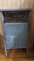 Front view of Economy Canadian metal washboard showing corrugated metal scrubbing surface and wood frame with stamp details.