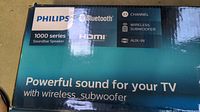Box showing Philips 1000 Series Soundbar Speaker with Bluetooth, HDMI, 2.1 channel, wireless subwoofer, and AUX-IN features.