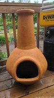 Front side view of pottery chiminea showing round belly and tall chimney.