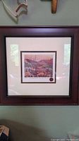 Full view of the professionally framed and matted Fireswept Hills print showing the dark brown frame and white matting with a glimpse of the artwork inside