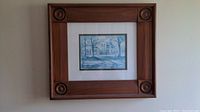 Framed artwork hung on a wall showing the wood frame and overall dimensions.