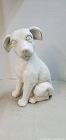 Front view of the white ceramic puppy dog figurine sitting with head slightly tilted forward and ears floppy.