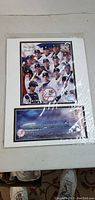 Full view of the New York Yankees collectible print collage with player images and logo, sealed in plastic.