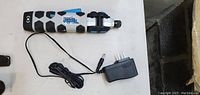 Photo of the blue and white rechargeable electric screwdriver with a black power adapter charger on a white surface