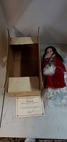 Original cardboard box opened showing certificate and wrapped doll.
