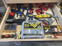 Drawer with tools including Irwin clamps, Stanley level, deluxe pocket hole jig kit, hammer, pliers, scissors, and DEWALT drill bits