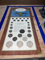 Wooden display board showing full layout of United States coins from 1900 to 1971 with eagle emblem and title.