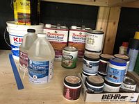 Overall photo showing multiple paint, stain, epoxy and wood finishing products on shelf.