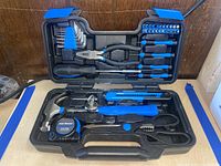 Full open view of 39 piece Cartman tool kit in black plastic case with blue accents on a wooden surface