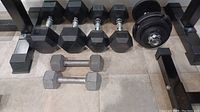 Photo showing all weights laid out on the floor including 30 lb adjustable dumbbell, 20 lb and 10 lb fixed dumbbells