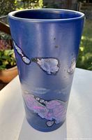 Front view of tall blue vase with abstract colorful glaze spots