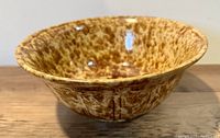 Side angle showing the flared rim and brown splatter glazing inside and outside the bowl.