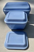 Top view showing the three blue Pyrex containers with matching lids and one lid removed.