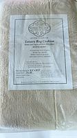 Beige-colored luxury rug cushion pad inside plastic packaging. Label indicates brand Royal Palace Handmade Rugs with product name Luxury Rug Cushion.