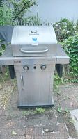 Front view of the Char-Broil Professional gas BBQ grill showing stainless steel hood, control knobs, and handle.