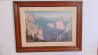 Framed landscape signed print showing entire artwork and wooden frame with minor wear.