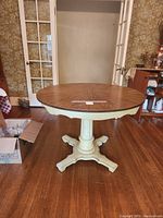 Round wooden pedestal table with a sunburst grain tabletop shown in round configuration.
