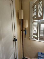 Vintage mid century modern floor to ceiling lamp placed between wall and window showing full height and placement.