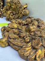 Close-up image showing detailed carving and gilded finish of cherub wall hanging.