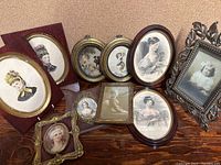 Full view of the 10 Victorian-style picture frames arranged together, showcasing different shapes, designs, and portraits of women and a child in period clothing